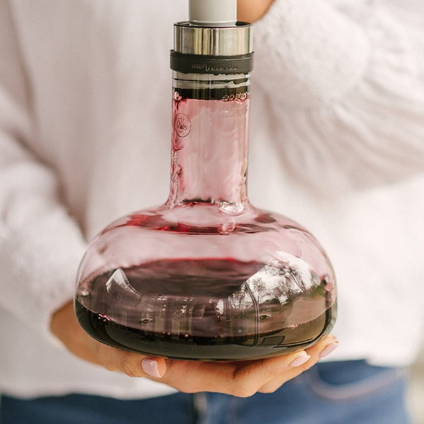 Red wine flowing into glass decanter